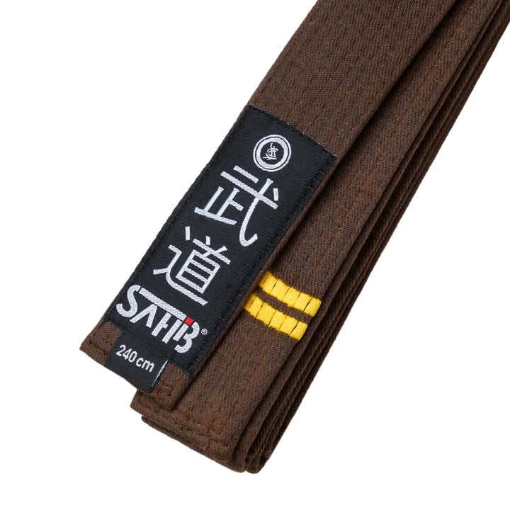 Detail shot of brown karate belt with two embroidered gold stripes