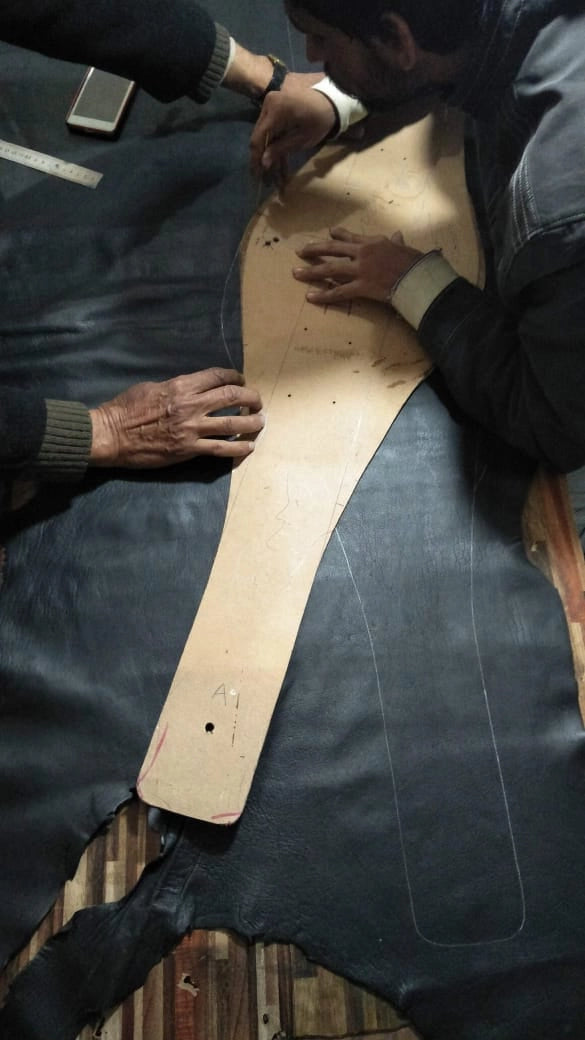 Aligning leather strap with plate mold layout during belt production.