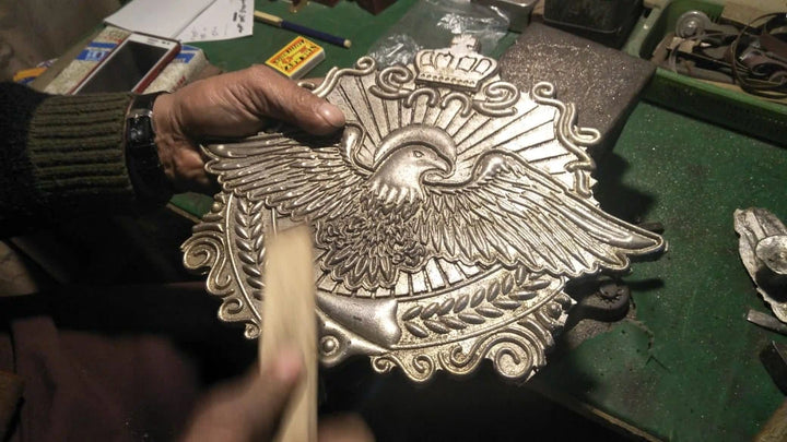 Raw metal plate just after casting, being prepared for engraving on custom belt.
