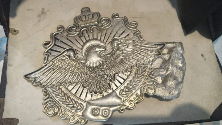 Close-up of unfinished eagle plate showing raw texture before polishing and plating.